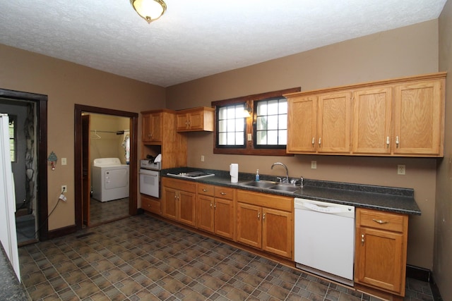 kitchen featuring a textured ceiling, white appliances, sink, and washer / clothes dryer