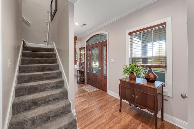 foyer with hardwood / wood-style floors and crown molding