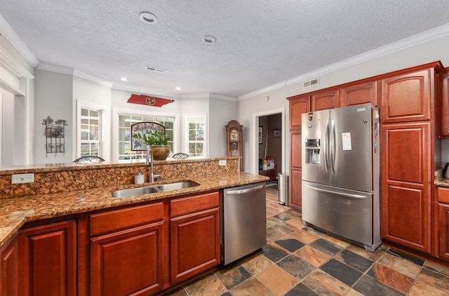 kitchen featuring crown molding, sink, a textured ceiling, appliances with stainless steel finishes, and light stone counters