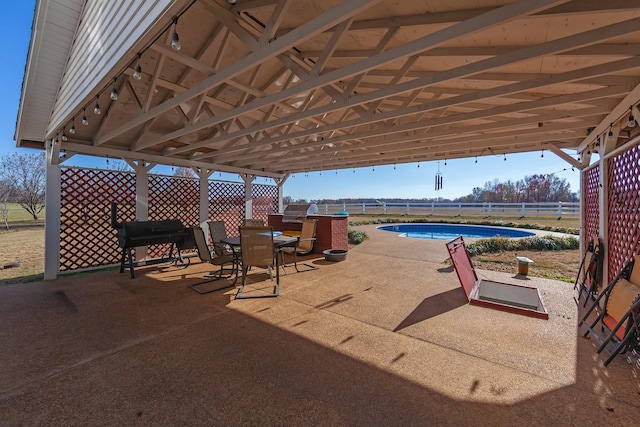 view of patio featuring a fenced in pool and area for grilling