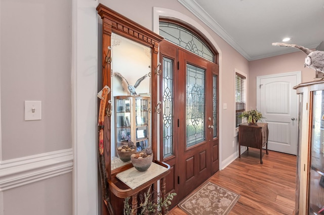 entryway featuring wood-type flooring and ornamental molding