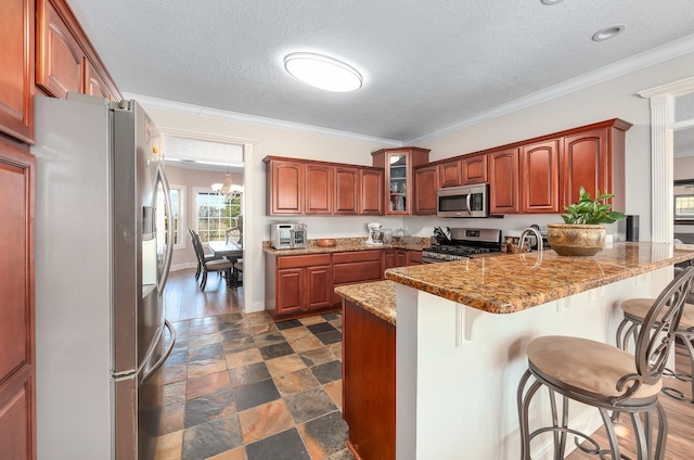 kitchen featuring a chandelier, appliances with stainless steel finishes, a textured ceiling, and crown molding