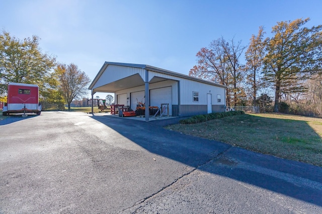 view of home's exterior with a garage, an outdoor structure, and a lawn