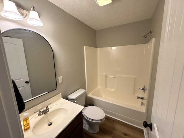 full bathroom with shower / bathtub combination, vanity, a textured ceiling, wood-type flooring, and toilet