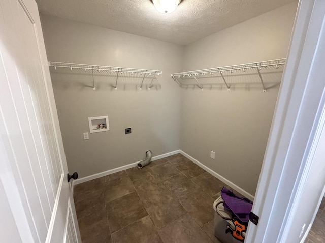 clothes washing area featuring hookup for a washing machine, a textured ceiling, and hookup for an electric dryer