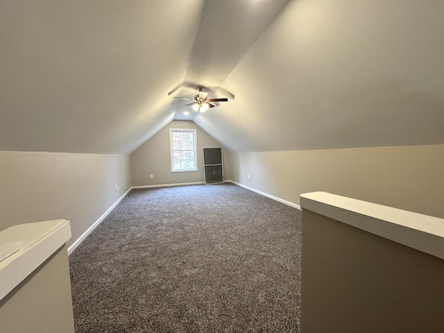 bonus room featuring ceiling fan, dark carpet, and vaulted ceiling