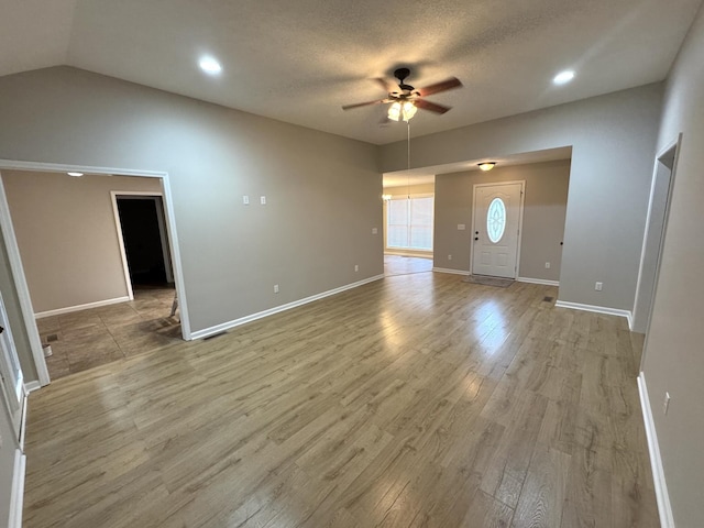 foyer featuring a textured ceiling, hardwood / wood-style flooring, ceiling fan, and lofted ceiling