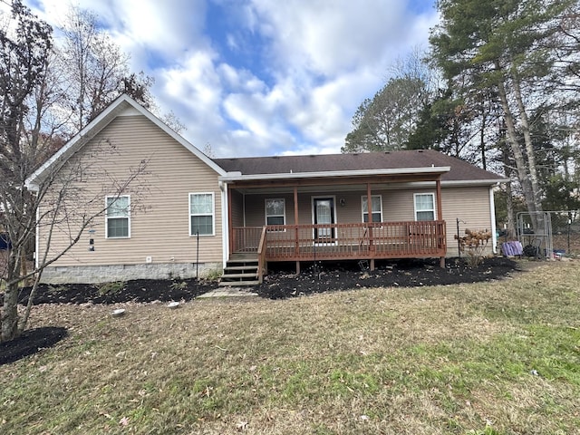 rear view of property featuring a lawn