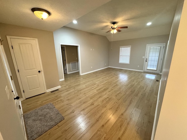 unfurnished room featuring ceiling fan, light wood-type flooring, and a textured ceiling