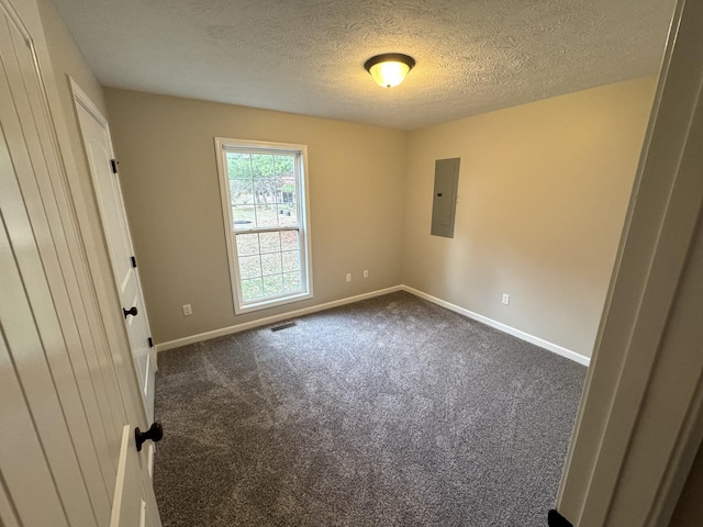 carpeted empty room featuring electric panel and a textured ceiling