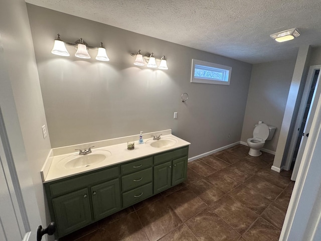 bathroom with vanity, a textured ceiling, and toilet