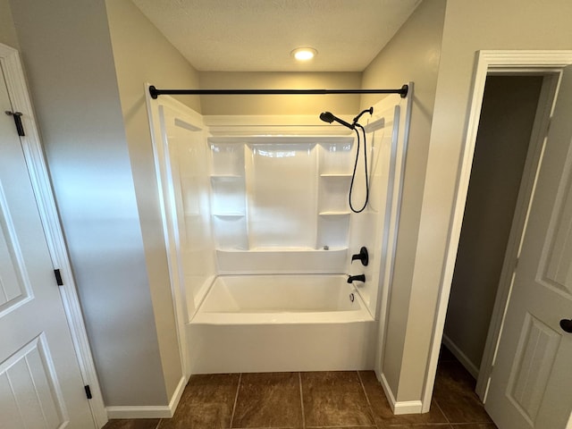 bathroom with a textured ceiling,  shower combination, and tile patterned floors