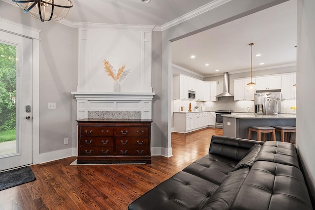 living room featuring dark hardwood / wood-style flooring, crown molding, and a chandelier