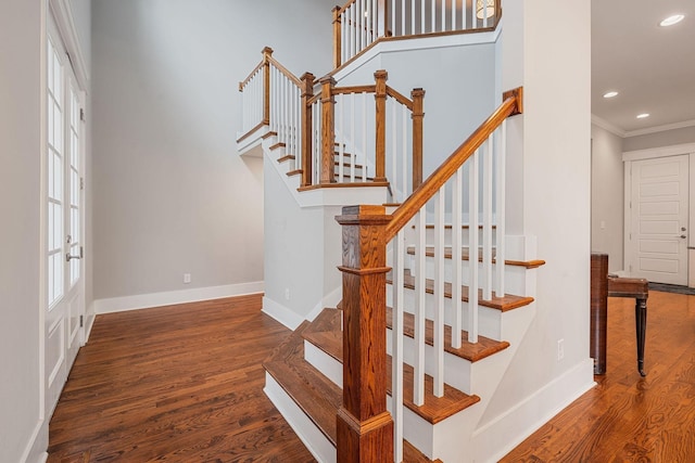 staircase with crown molding and hardwood / wood-style flooring