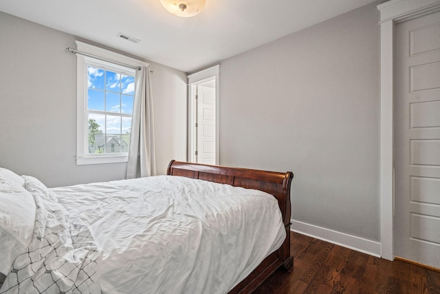 bedroom with dark hardwood / wood-style flooring