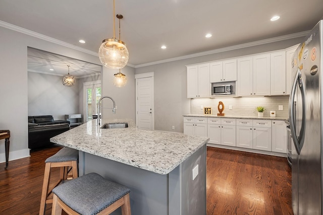 kitchen with pendant lighting, sink, dark wood-type flooring, and appliances with stainless steel finishes