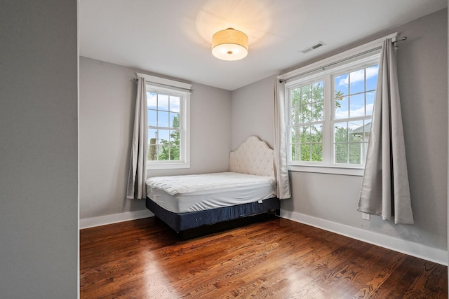 bedroom with dark hardwood / wood-style floors