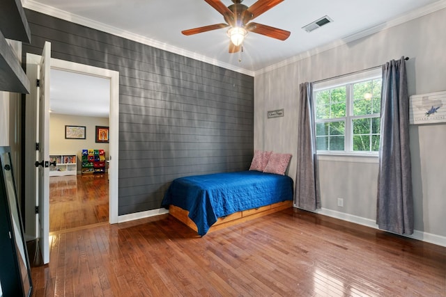 bedroom featuring ceiling fan, wood-type flooring, and ornamental molding