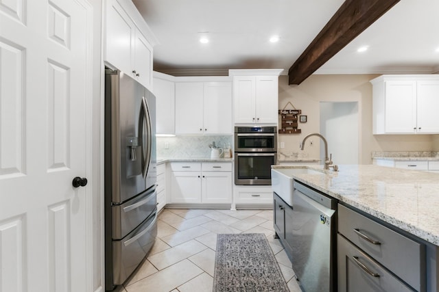 kitchen featuring light stone countertops, appliances with stainless steel finishes, sink, beamed ceiling, and white cabinets