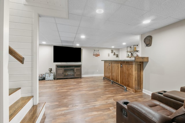 bar featuring a paneled ceiling and hardwood / wood-style flooring