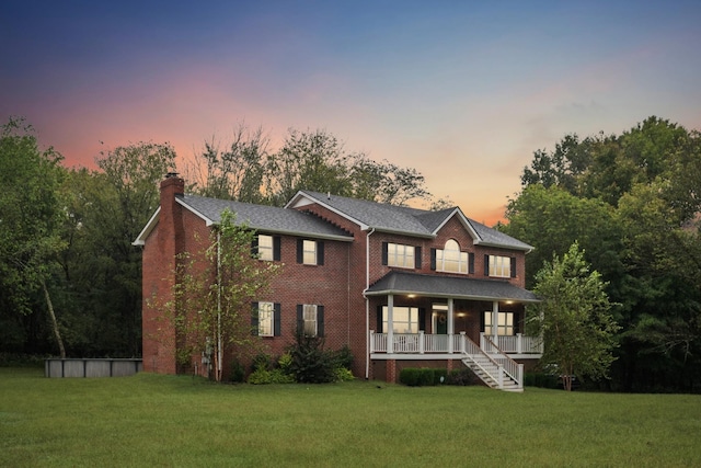 view of front of property featuring a lawn and a porch