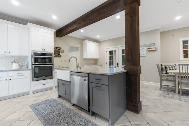 kitchen with white cabinets, gray cabinets, an island with sink, beam ceiling, and stainless steel appliances