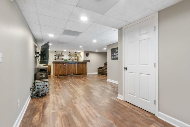 bar with hardwood / wood-style floors and a drop ceiling