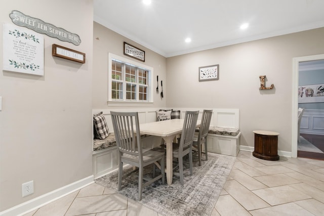 dining area with light tile patterned floors and ornamental molding