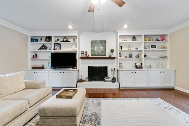 living room with a fireplace, dark hardwood / wood-style flooring, ceiling fan, and crown molding