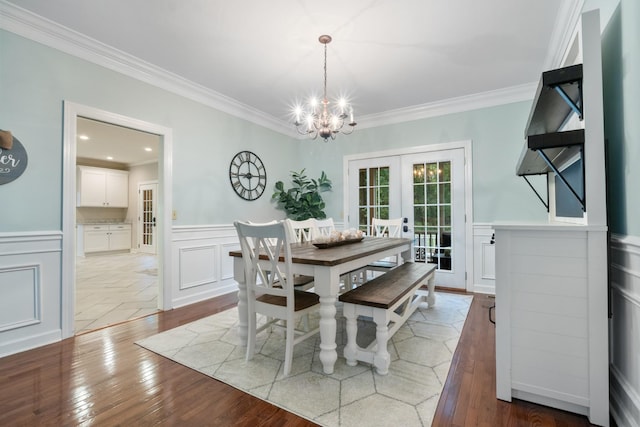 dining space featuring french doors, hardwood / wood-style flooring, and crown molding