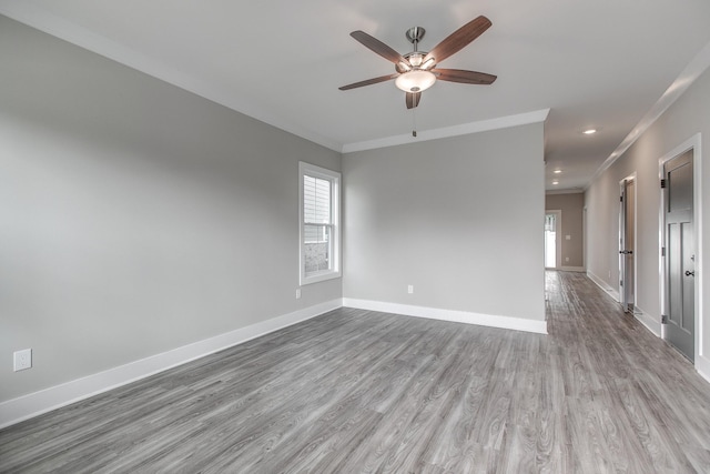 empty room featuring ceiling fan, crown molding, and light hardwood / wood-style flooring