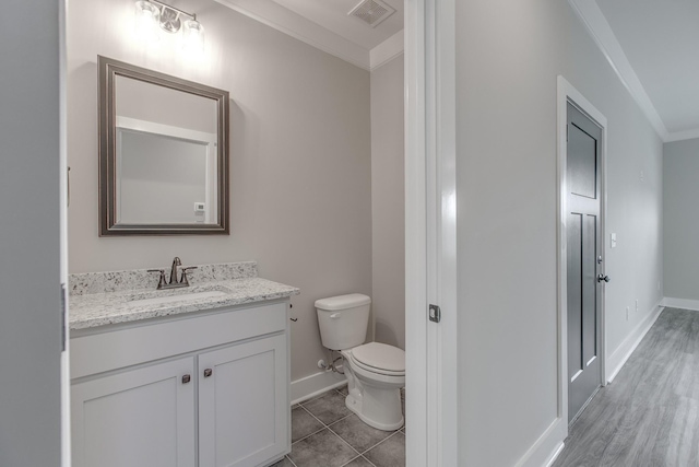 bathroom featuring hardwood / wood-style floors, vanity, toilet, and ornamental molding