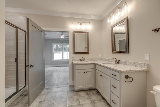 bathroom with ceiling fan, tile patterned flooring, crown molding, vanity, and a shower with shower door