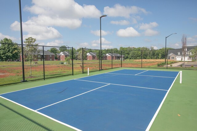 view of tennis court with basketball hoop