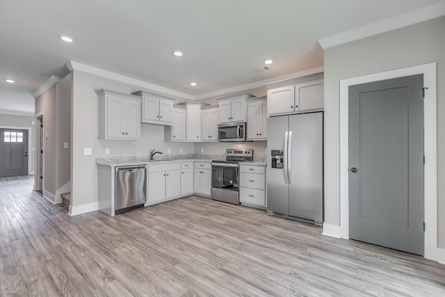 kitchen with crown molding, sink, light wood-type flooring, and stainless steel appliances