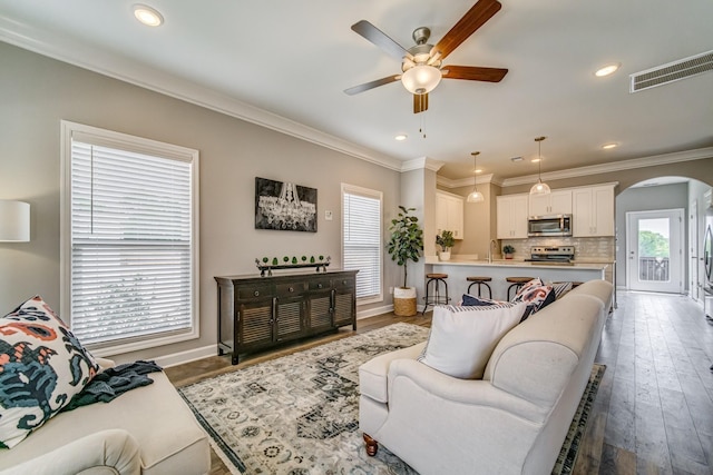 living room with crown molding, a healthy amount of sunlight, and hardwood / wood-style flooring