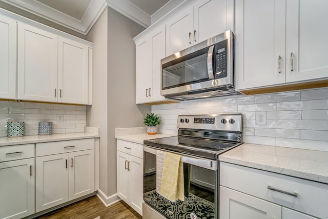 kitchen featuring backsplash, crown molding, dark hardwood / wood-style floors, appliances with stainless steel finishes, and white cabinetry