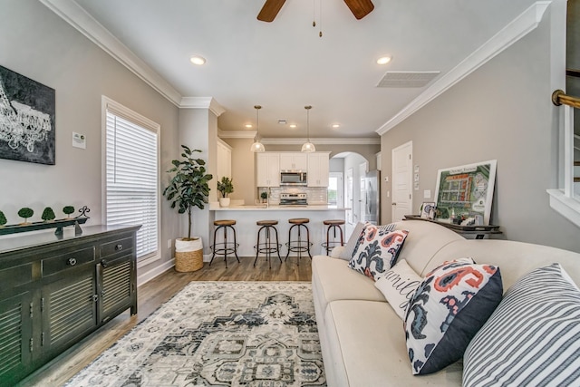 living room featuring ceiling fan, hardwood / wood-style floors, and ornamental molding