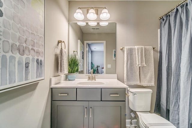 bathroom featuring a shower with curtain, vanity, and toilet