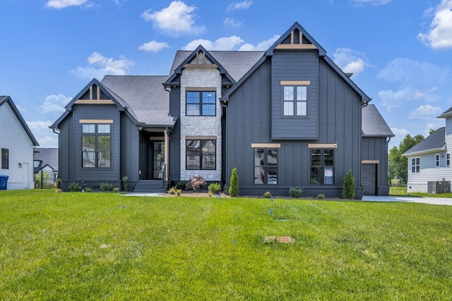 modern farmhouse with cooling unit, a front yard, and a garage