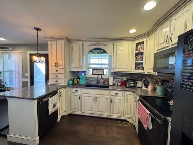 kitchen featuring backsplash, dark stone counters, sink, black appliances, and decorative light fixtures