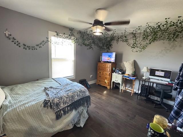 bedroom with ceiling fan and dark wood-type flooring