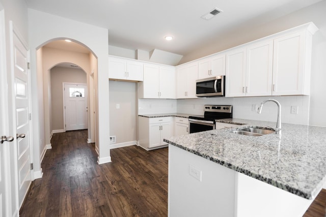 kitchen featuring appliances with stainless steel finishes, dark hardwood / wood-style flooring, light stone counters, sink, and white cabinets