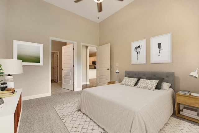 bedroom with ceiling fan, high vaulted ceiling, and light carpet