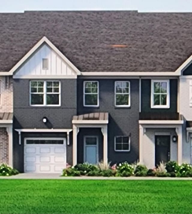 townhome / multi-family property featuring a front lawn and a garage