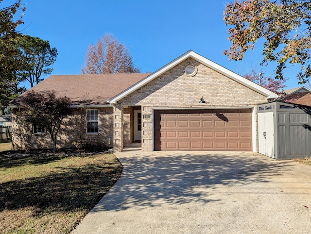 single story home featuring a garage, a storage shed, and a front yard