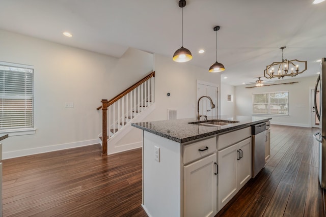 kitchen featuring dark stone counters, sink, a center island with sink, dark hardwood / wood-style floors, and white cabinetry