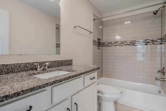 full bathroom with vanity, tiled shower / bath combo, and toilet