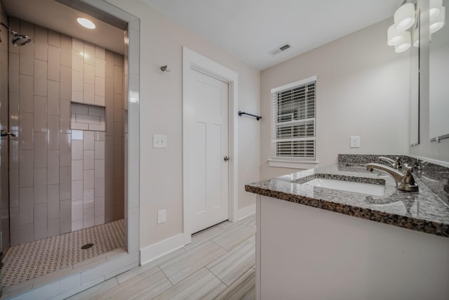 bathroom featuring a tile shower and vanity