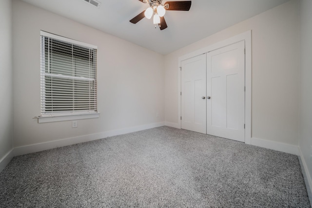 unfurnished bedroom featuring carpet floors, a closet, and ceiling fan